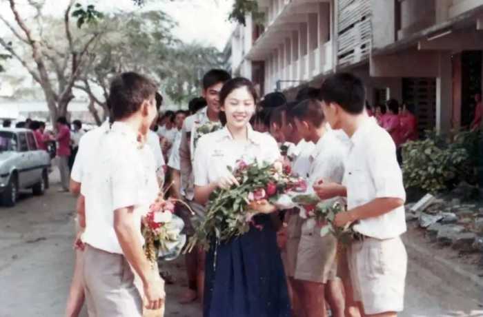 1984年，17岁的英拉手捧鲜花走在清迈的大街上，看起来十分清纯