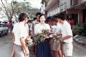 1984年，17岁的英拉手捧鲜花走在清迈的大...